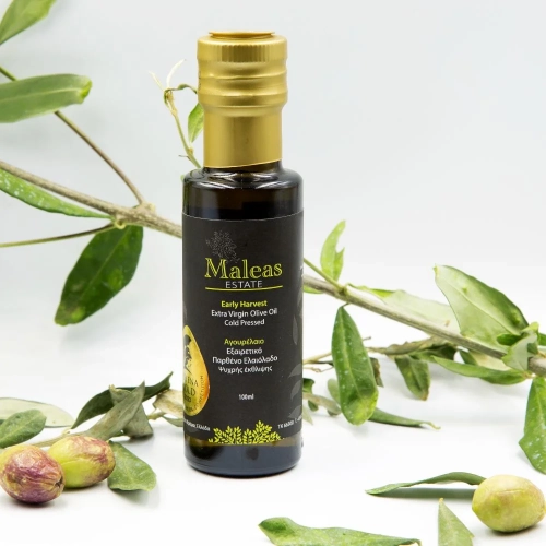 Eine 100 ml Flasche des frühgepressten Oliven Öls und das in mitten von Oliven und Oliven Zweigen steht.